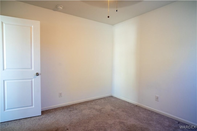 carpeted spare room featuring baseboards