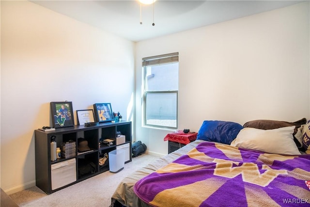 bedroom featuring ceiling fan, baseboards, and light colored carpet