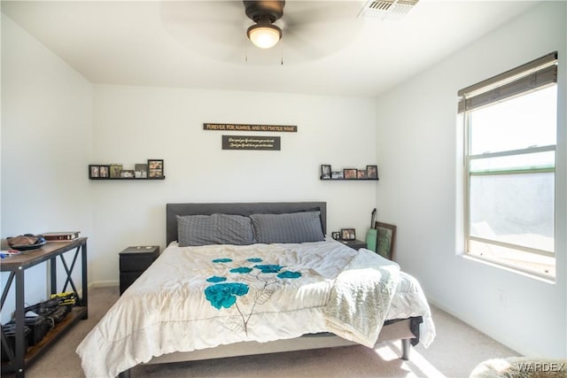 carpeted bedroom featuring a ceiling fan and visible vents