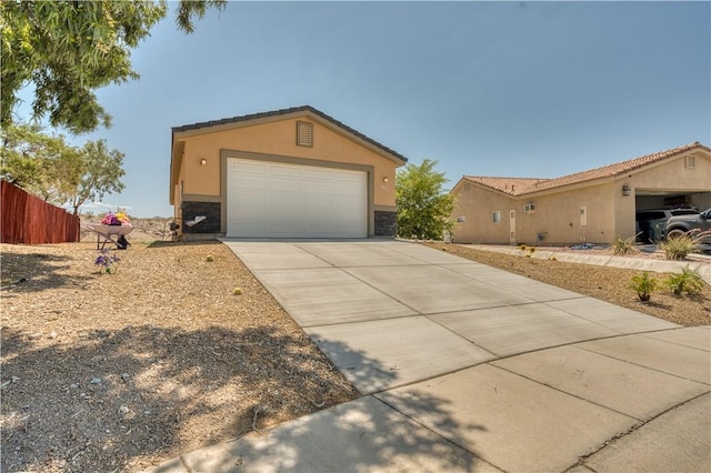 3492 Tres Alamos Dr, Bullhead City, AZ 86442 - view of front of home with stone siding, stucco siding, and driveway