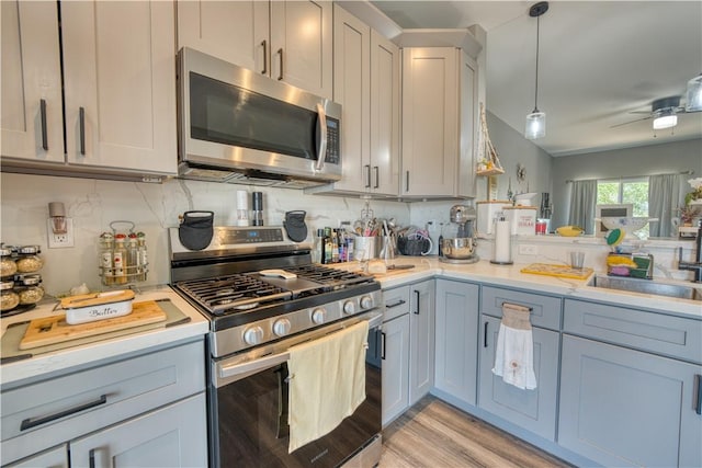 3492 Tres Alamos Dr, Bullhead City, AZ 86442 - kitchen featuring stainless steel appliances, light countertops, ceiling fan, and light wood finished floors