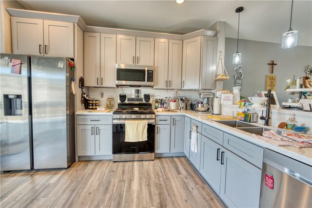 3492 Tres Alamos Dr, Bullhead City, AZ 86442 - kitchen with appliances with stainless steel finishes, light countertops, decorative light fixtures, and light wood-style floors