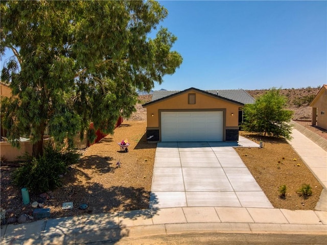 3492 Tres Alamos Dr, Bullhead City, AZ 86442 - view of front of home with stucco siding, driveway, and a garage