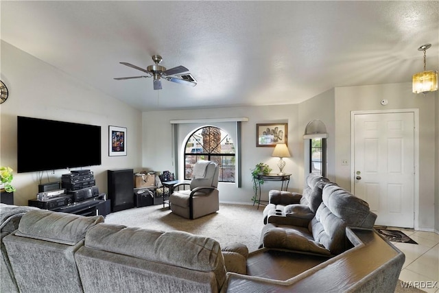 living area featuring vaulted ceiling, light colored carpet, a ceiling fan, and baseboards