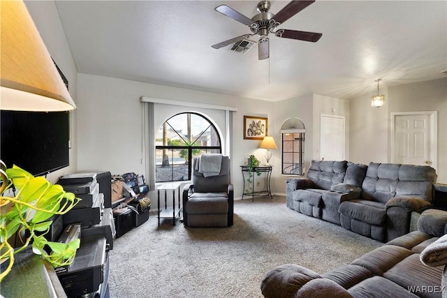 carpeted living room with ceiling fan, visible vents, and vaulted ceiling