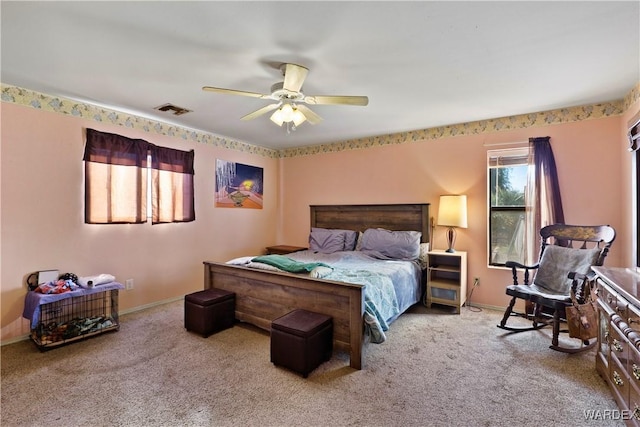 bedroom featuring light carpet, ceiling fan, visible vents, and baseboards