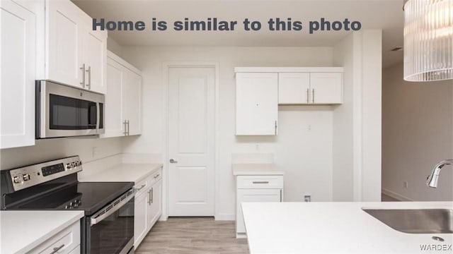 kitchen featuring white cabinetry, appliances with stainless steel finishes, and a sink