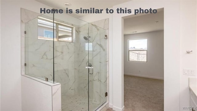 bathroom featuring a marble finish shower and baseboards