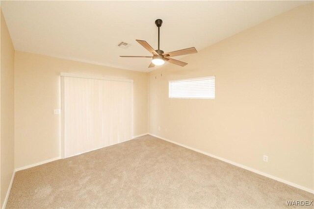 empty room with carpet floors, visible vents, baseboards, and a ceiling fan