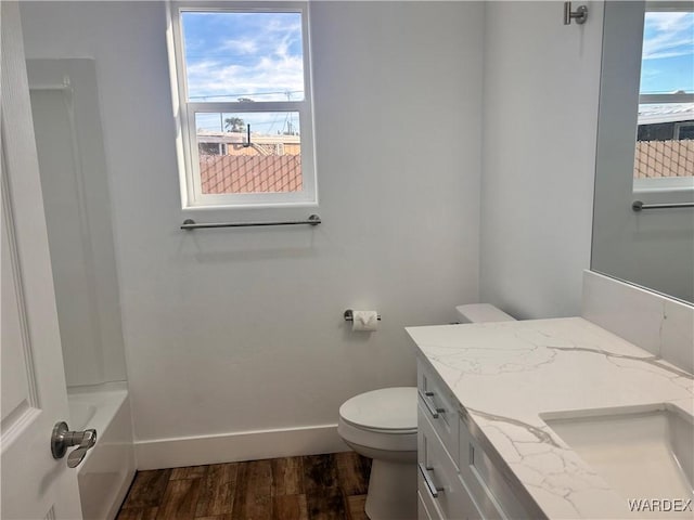 full bathroom featuring baseboards, toilet, wood finished floors, tub / shower combination, and vanity