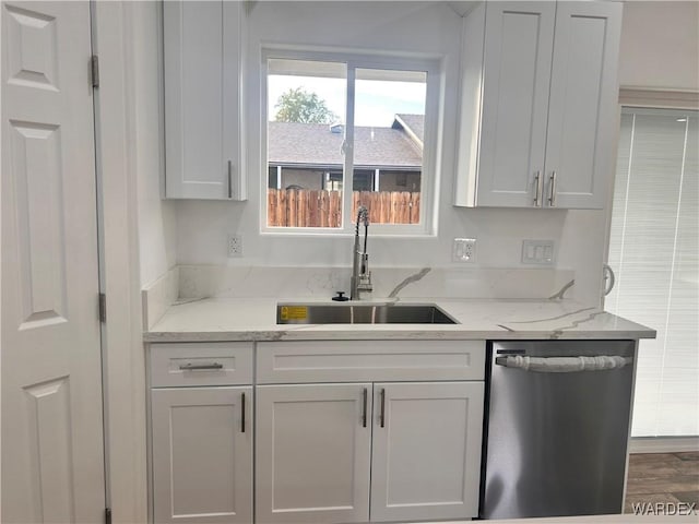 kitchen featuring a sink, light stone countertops, white cabinetry, and dishwasher