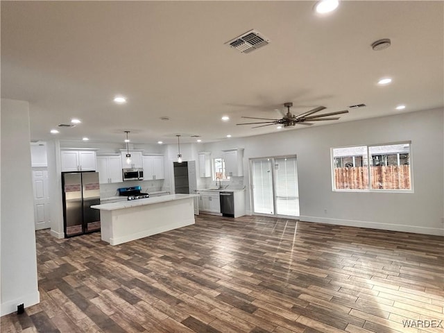 kitchen featuring visible vents, white cabinets, a center island, stainless steel appliances, and pendant lighting