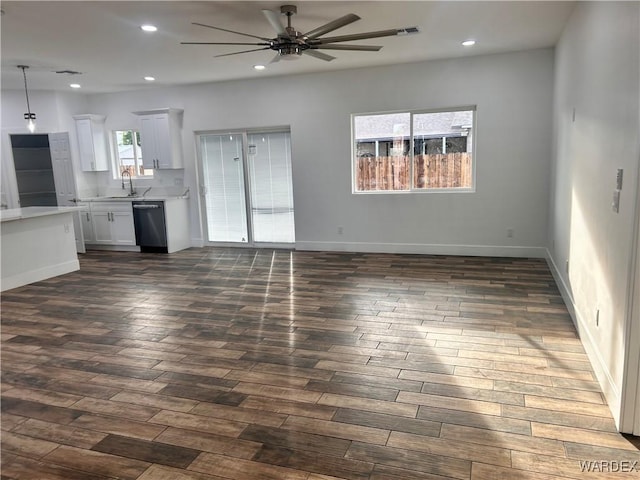 unfurnished living room with a ceiling fan, dark wood-type flooring, a sink, and recessed lighting