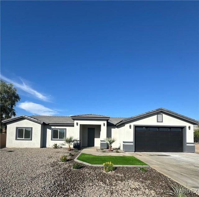 view of front of home featuring concrete driveway, an attached garage, and stucco siding