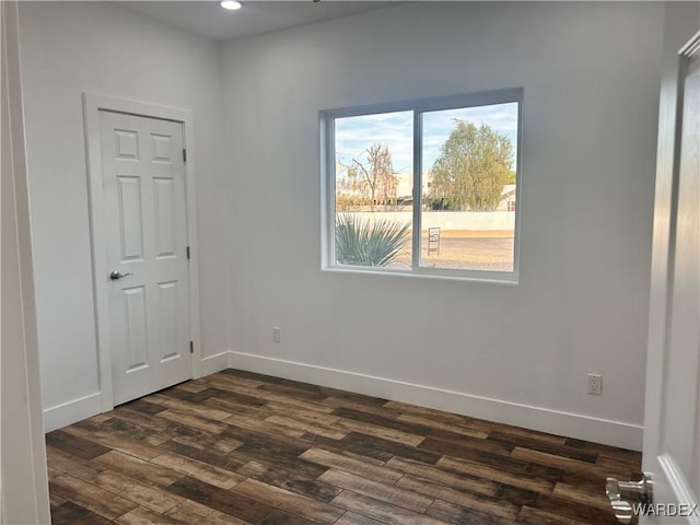 unfurnished room with recessed lighting, dark wood finished floors, and baseboards