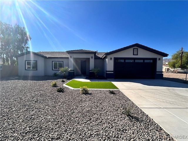 view of front of home with driveway, an attached garage, and stucco siding