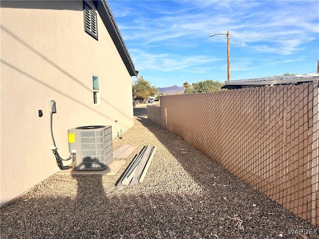 view of yard with fence and central air condition unit