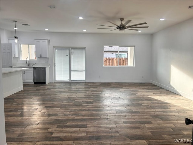 unfurnished living room featuring dark wood-type flooring, recessed lighting, ceiling fan, and baseboards