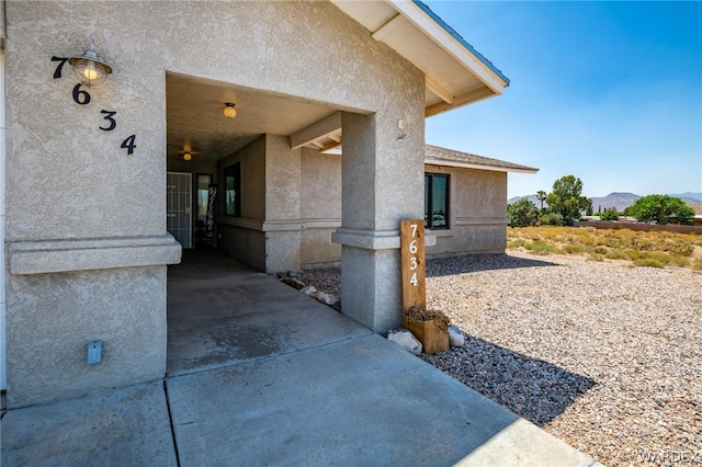 exterior space with a mountain view and stucco siding