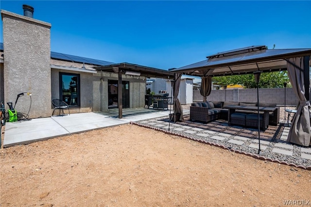 view of patio featuring grilling area, fence, an outdoor living space, and a gazebo