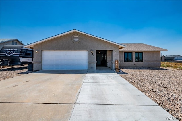 ranch-style home with concrete driveway, a shingled roof, an attached garage, and stucco siding