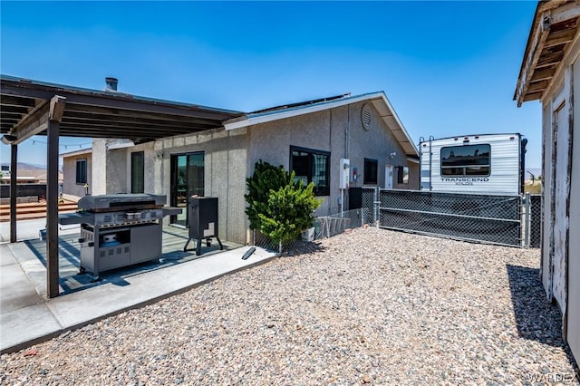 view of property exterior featuring a patio area, fence, and stucco siding