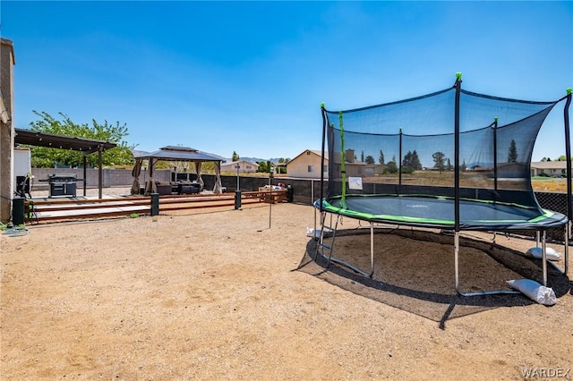 view of yard with a trampoline and a gazebo