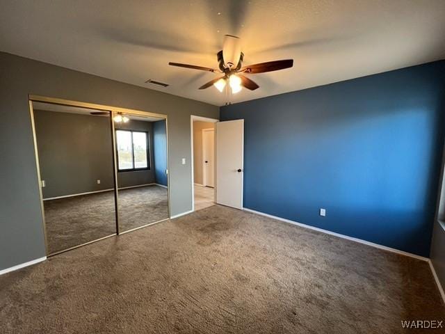 unfurnished bedroom featuring carpet floors, a closet, visible vents, and baseboards