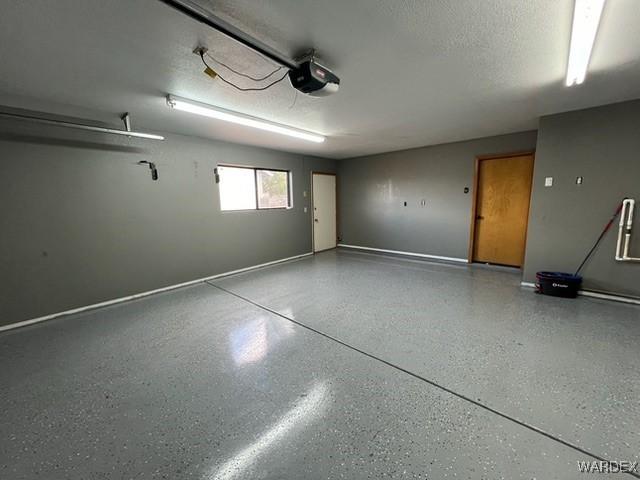 garage featuring a garage door opener and baseboards