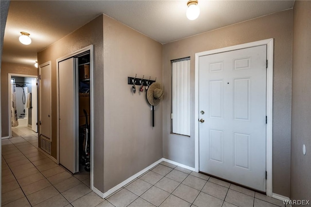 entrance foyer with baseboards and light tile patterned floors