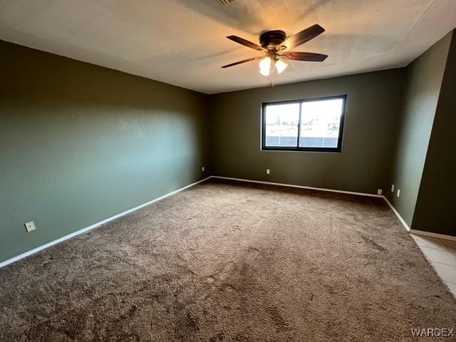 empty room with baseboards, a ceiling fan, and light colored carpet