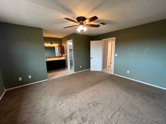 unfurnished bedroom featuring baseboards, visible vents, connected bathroom, and light colored carpet