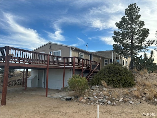 rear view of house featuring a wooden deck and stairs