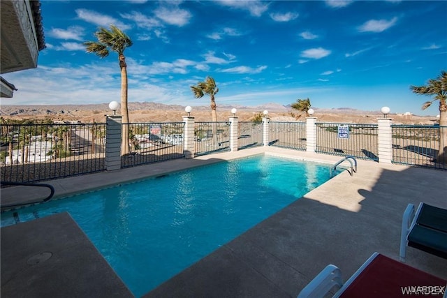 pool with fence and a mountain view