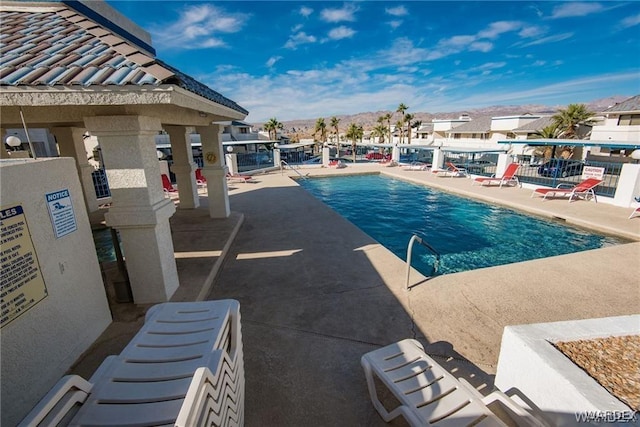 pool with a patio area and fence