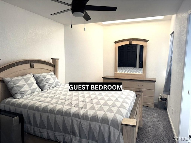 bedroom featuring ceiling fan, a textured wall, dark carpet, and baseboards