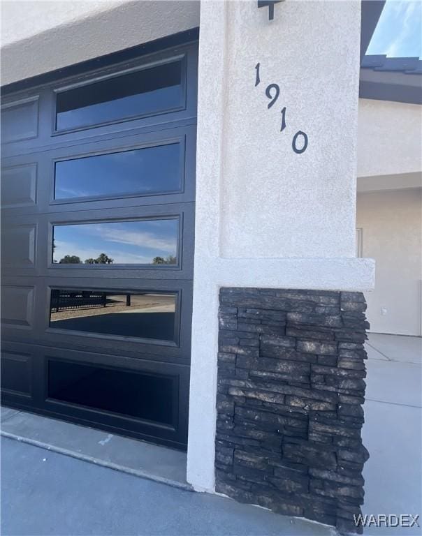 doorway to property featuring a garage and stucco siding