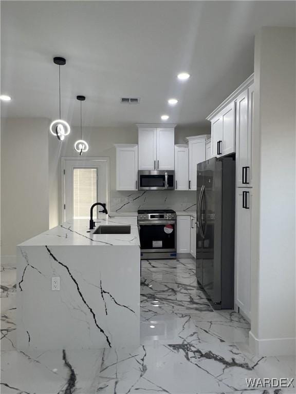 kitchen with visible vents, appliances with stainless steel finishes, light stone counters, decorative light fixtures, and white cabinetry