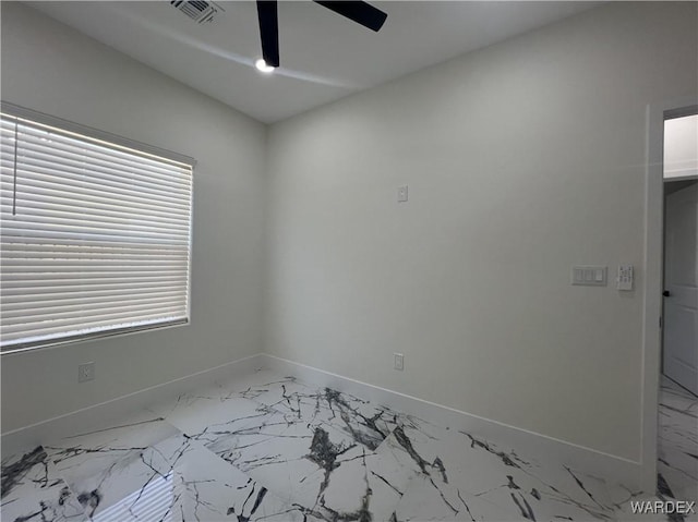 empty room featuring ceiling fan, marble finish floor, visible vents, and baseboards