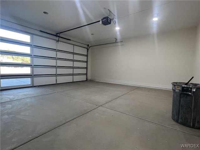 garage with baseboards and a garage door opener