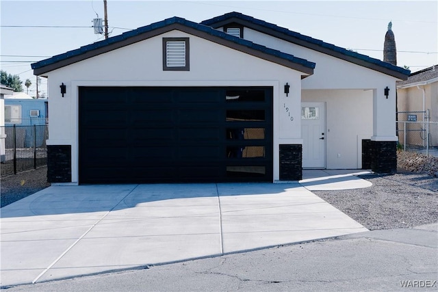 view of front of property with a garage, fence, driveway, and stucco siding