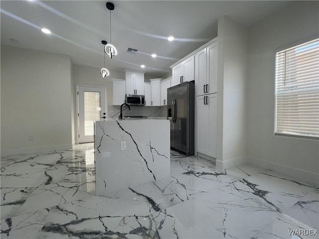 kitchen with white cabinets, light stone counters, decorative light fixtures, marble finish floor, and stainless steel appliances