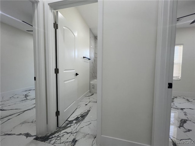 hall featuring marble finish floor and baseboards