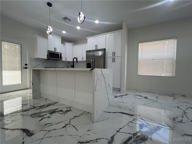 kitchen with stainless steel appliances, visible vents, white cabinets, light countertops, and decorative light fixtures