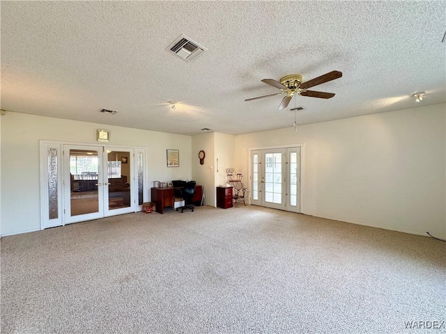 interior space featuring french doors, a textured ceiling, visible vents, and a ceiling fan