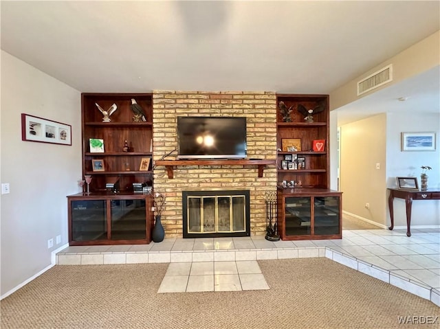 carpeted living area featuring visible vents, built in features, a fireplace, tile patterned flooring, and baseboards