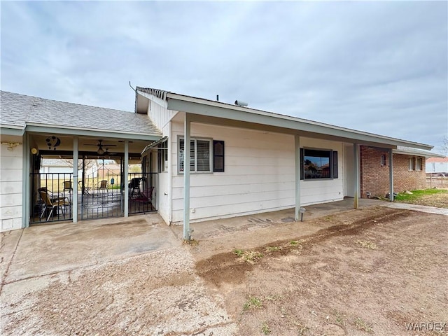 view of front of home with a carport, a ceiling fan, and a patio area