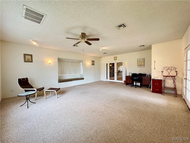 living area featuring french doors, carpet floors, visible vents, and ceiling fan