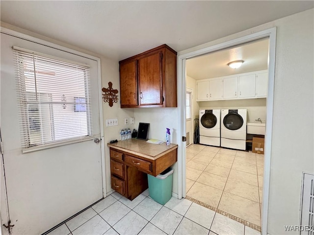 laundry room with washer and dryer, cabinet space, plenty of natural light, and light tile patterned floors