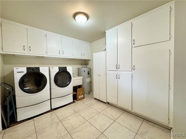 laundry area with water heater, light tile patterned floors, cabinet space, and washer and dryer